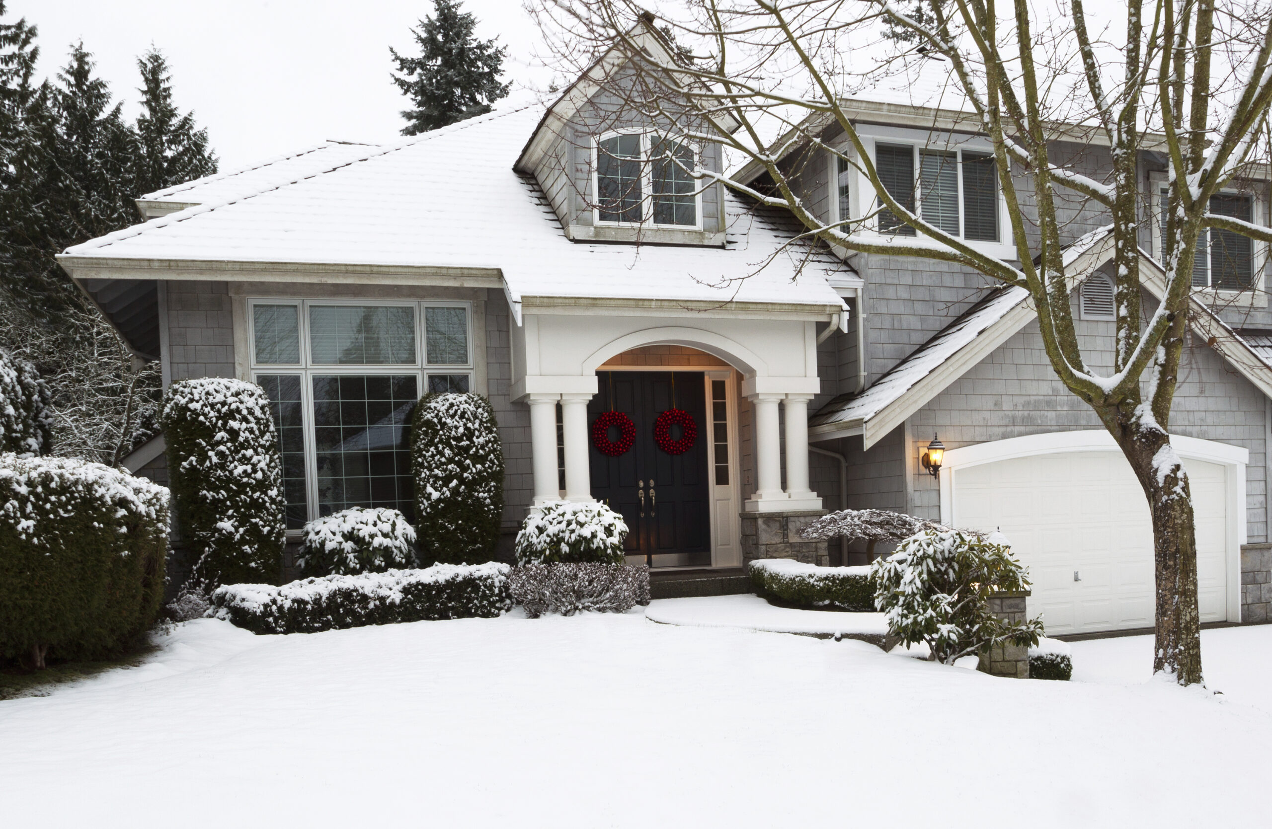 Beautiful home exterior with vinyl replacement windows in winter snow, energy-efficient upgrade by Thrush & Son