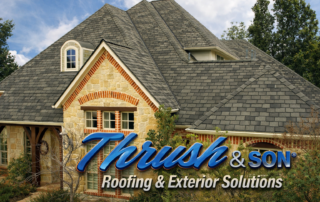 GAF Woodland shingles installed on a luxury home with stone and brick exterior showcasing detailed rooflines.