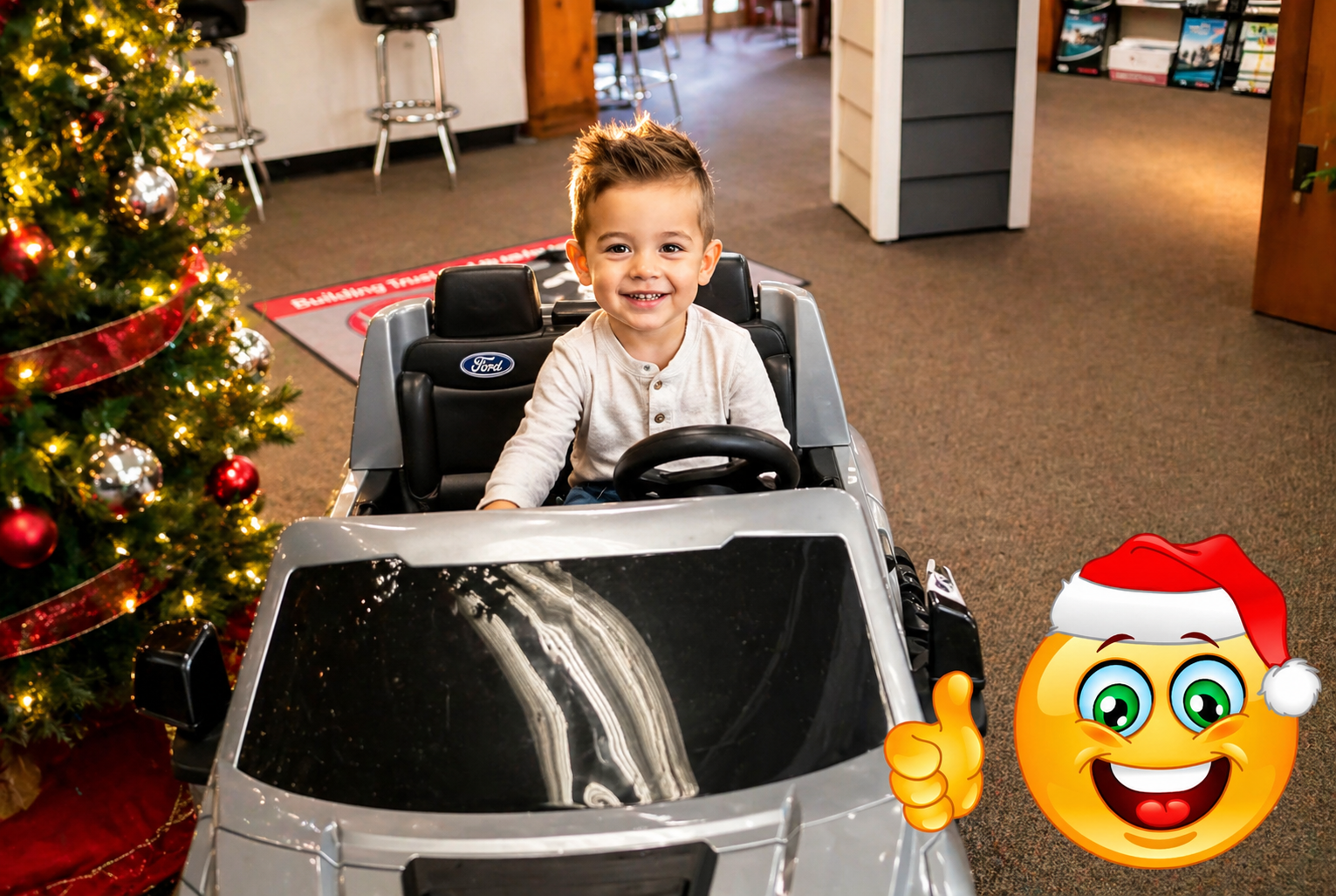 Toddler test driving a holiday toy truck at Thrush & Son showroom – could be yours this season.