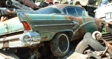 Rusting classic car in a junkyard showing long-term material failure, illustrating why the benefits of vinyl siding include durability, low maintenance, and resistance to weather damage