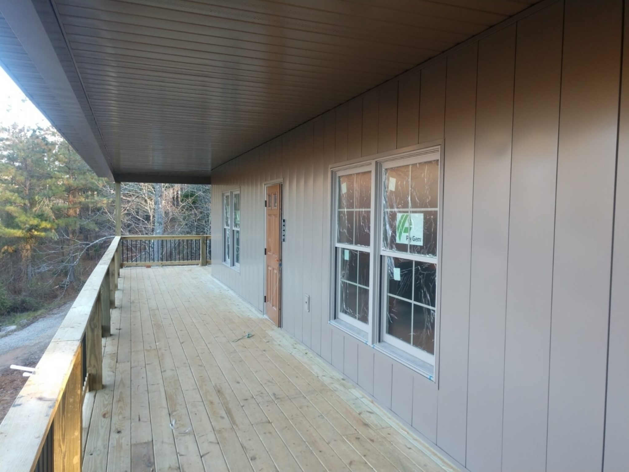 Covered porch featuring vertical steel siding with clean trim details and a finished soffit ceiling on a modern home exterior.