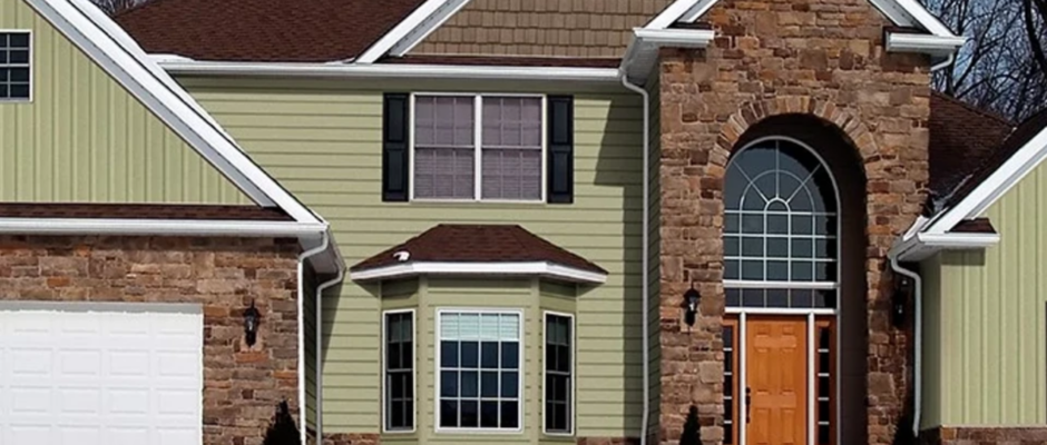 Residential home combining vertical vinyl siding with stone accents for enhanced curb appeal.