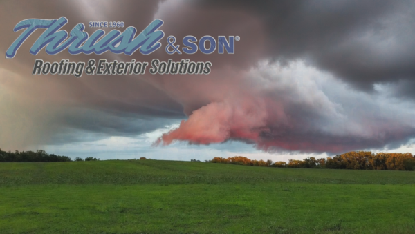 Storm system with dramatic clouds approaching over Dayton area landscape, representing weather damage risks to residential roofing by Thrush & Son.