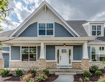 Energy efficient siding on modern suburban homes with light blue and gray vinyl panels, gable roofs, black shutters, and snow-covered ground, showcasing enhanced curb appeal, thermal performance, and all-weather protection in a winter neighborhood setting