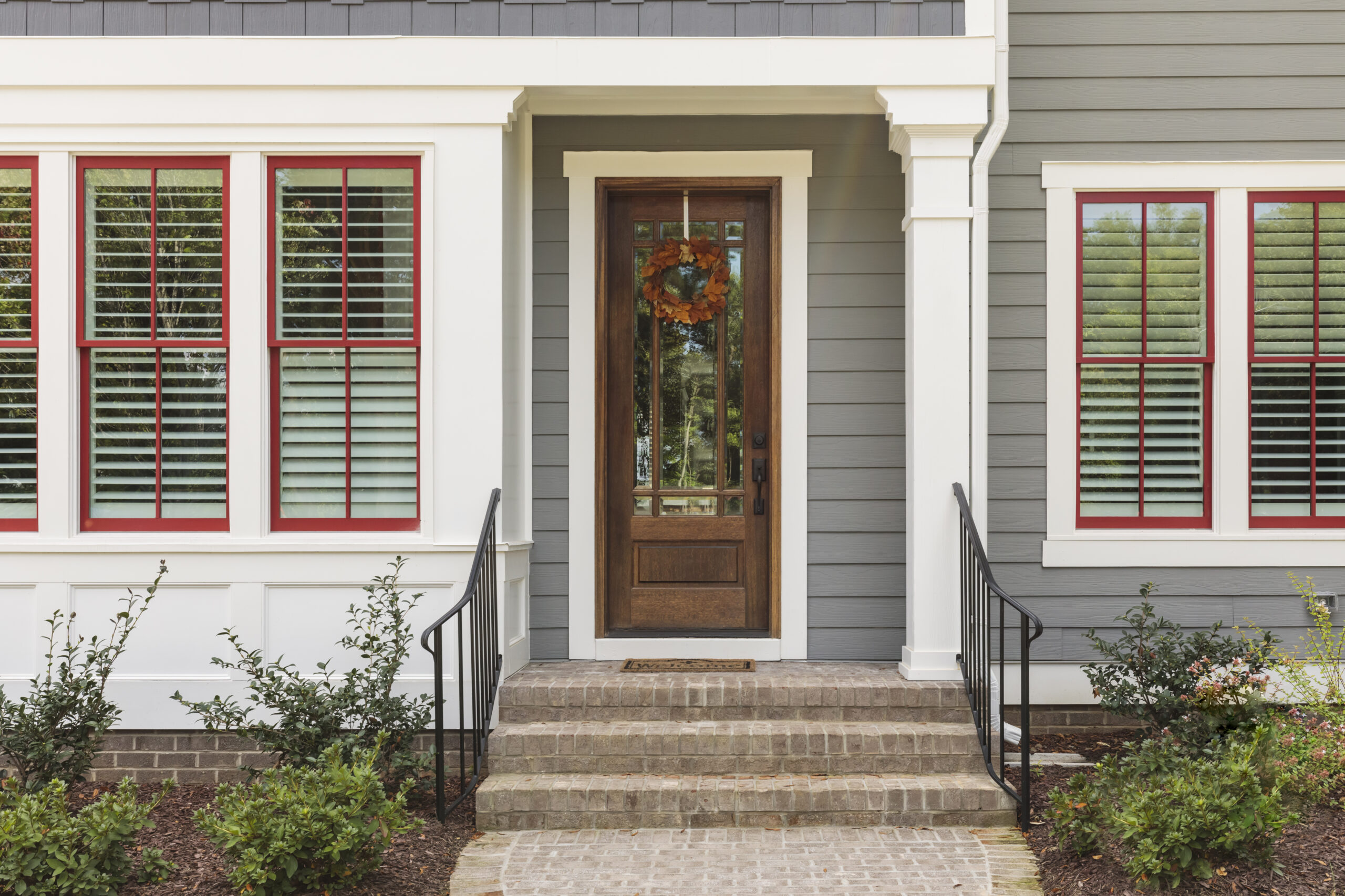 Entry Door replacement in Dayton, Ohio featuring a stylish blue front door with sidelights on a beautiful home