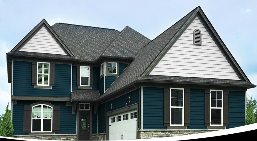 Vinyl Siding for Your Home: stunning two-story home with premium vinyl siding in dark blue, white trim & stone accents, boosting curb appeal and durability – Thrush & Son® exterior experts